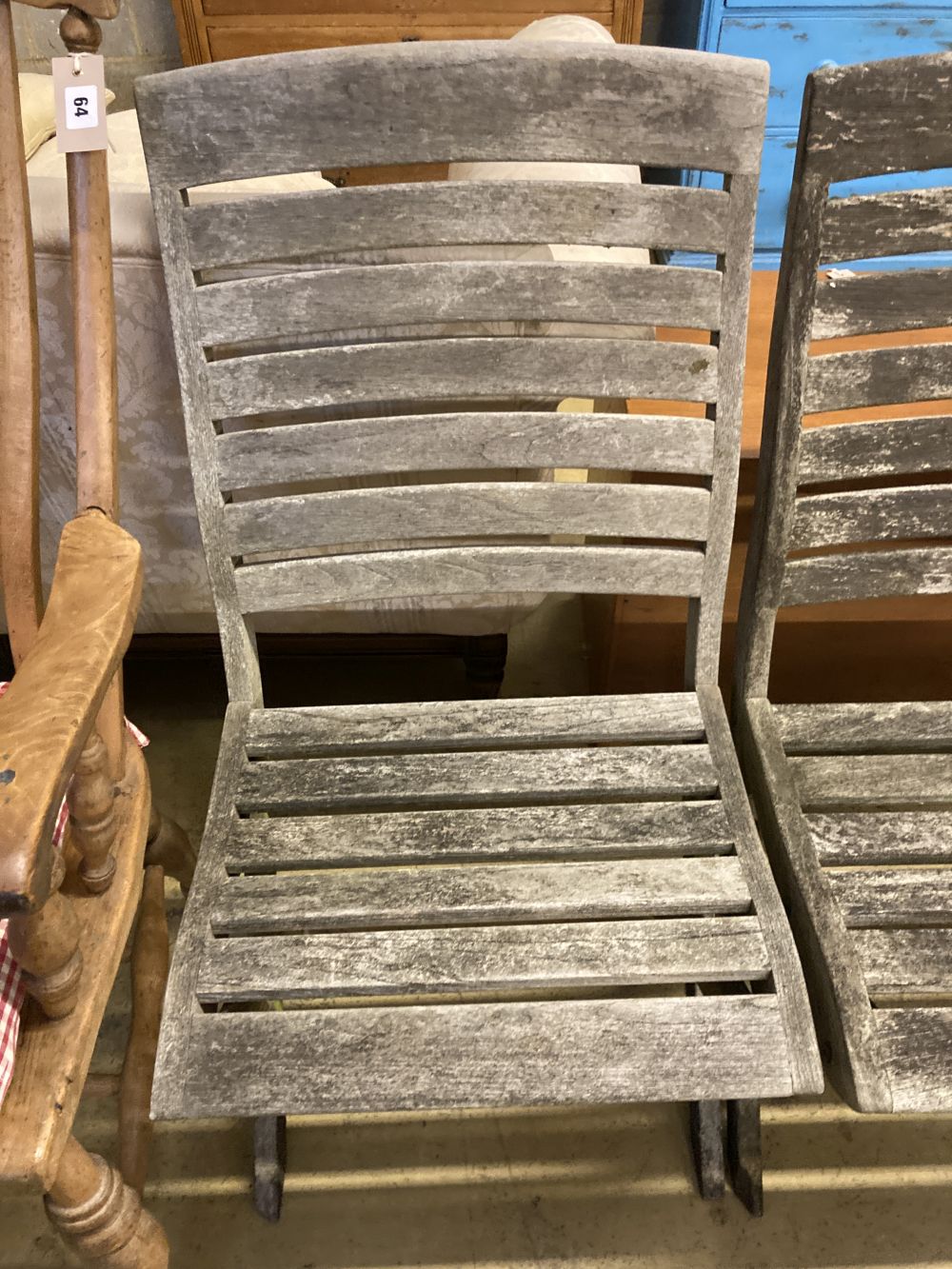 A set of four weathered teak folding garden chairs